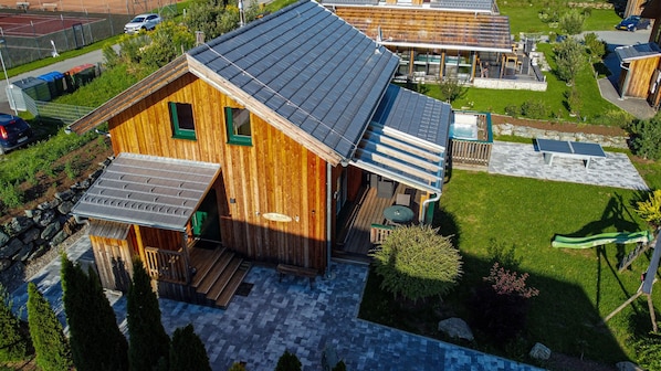 A wooden cabin with a sloped roof, a deck, and solar panels. - Murau 18 - Chalet with whirlpool & infrared sauna (Murau)