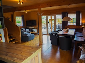 A wooden interior with a sofa, a dining table, and a TV. - Murau 18 - Chalet with whirlpool & infrared sauna (Murau)