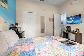 Une chambre à coucher avec un lit, un bureau, une télévision et une porte sur laquelle est apposée une pancarte.