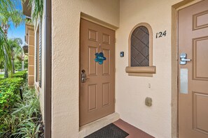 A brown door with a 'Welcome' sign, a mailbox, and a number '124' on the wall. - Cozy Studio - 20 minutes from Disney - LOWEST price in Regal Palms Resort (Davenport)