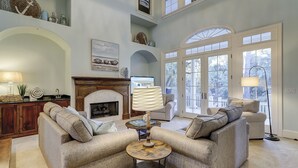 A spacious living room with a fireplace, two sofas, a coffee table, and a television.