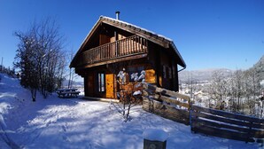 A wooden cabin with a balcony, surrounded by snow-covered trees and a clear blue sky. - A L'orée du Bois (Dommartin-lès-Remiremont)