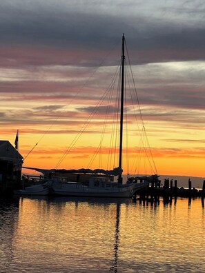 Ein Yachthafen mit Booten, die an hölzernen Stegen im Sonnenuntergang liegen.