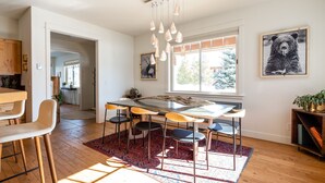 A modern kitchen with a central island, bar stools, and pendant lighting. - Big Sky Escape - Spacious Home with Hot Tub (Big Sky)