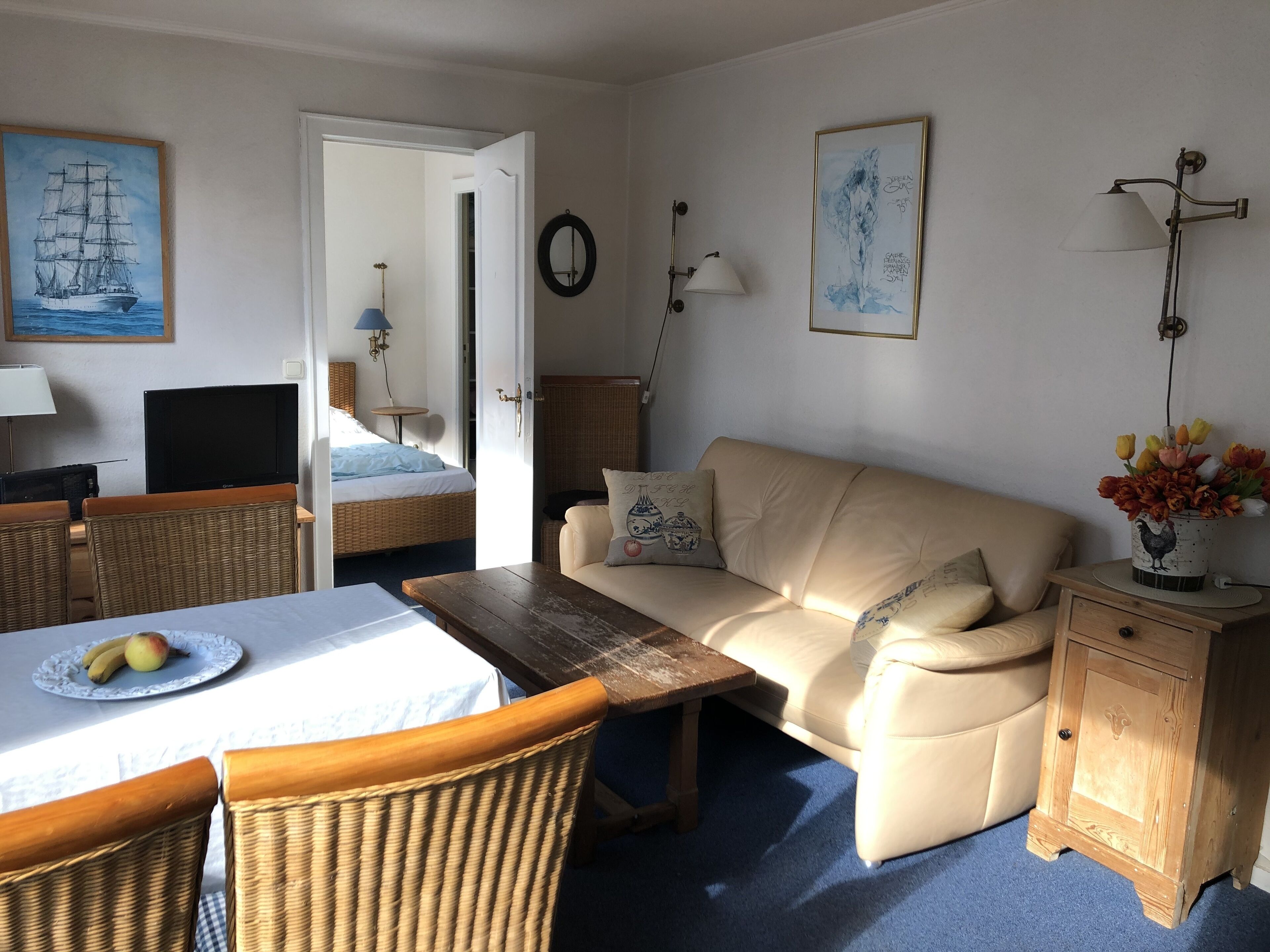 A cozy room with a bed, a sofa, a dining table, and a TV.