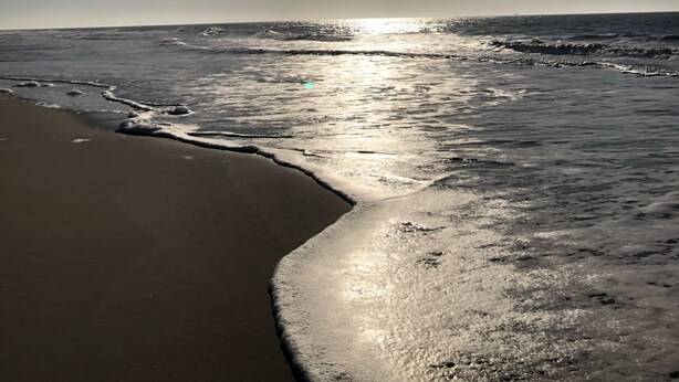 A beach with waves and a clear sky. - Bright, cozy vacation apartment in a perfect location close to the beach and town center  (Sylt)