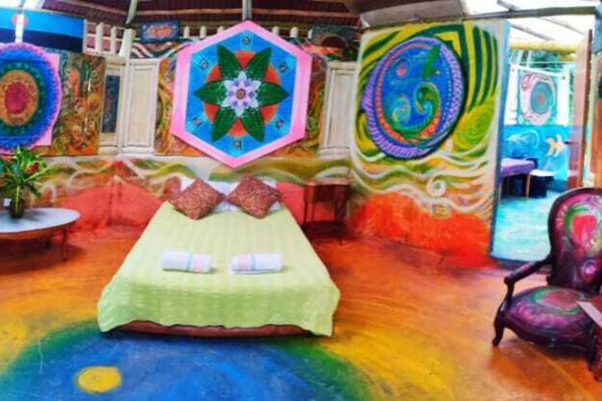 A colorful room with a bed, a chair, and a table.