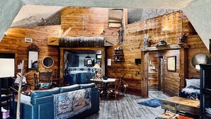 Ein gemütliches Interieur im Chalet-Stil mit Schlafzimmer im Erker und Essbereich sowie Küche.