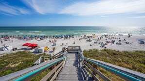A beach with a staircase leading down to the shore, surrounded by beachgoers and umbrellas. - Seacrest Beach 30A | Lower Nightly Rates | My Beach Getaways (Seacrest Beach)