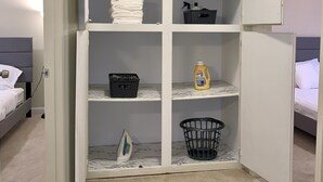 Un armario vestidor con puertas abiertas, estantes y una barra para colgar ropa.