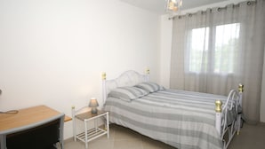 A bedroom with a bed, a desk, and a nightstand. - Modern holiday home with heated pool (Pradons)