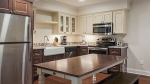 Una cocina moderna con electrodomésticos de acero inoxidable, encimera de granito y armarios de madera.