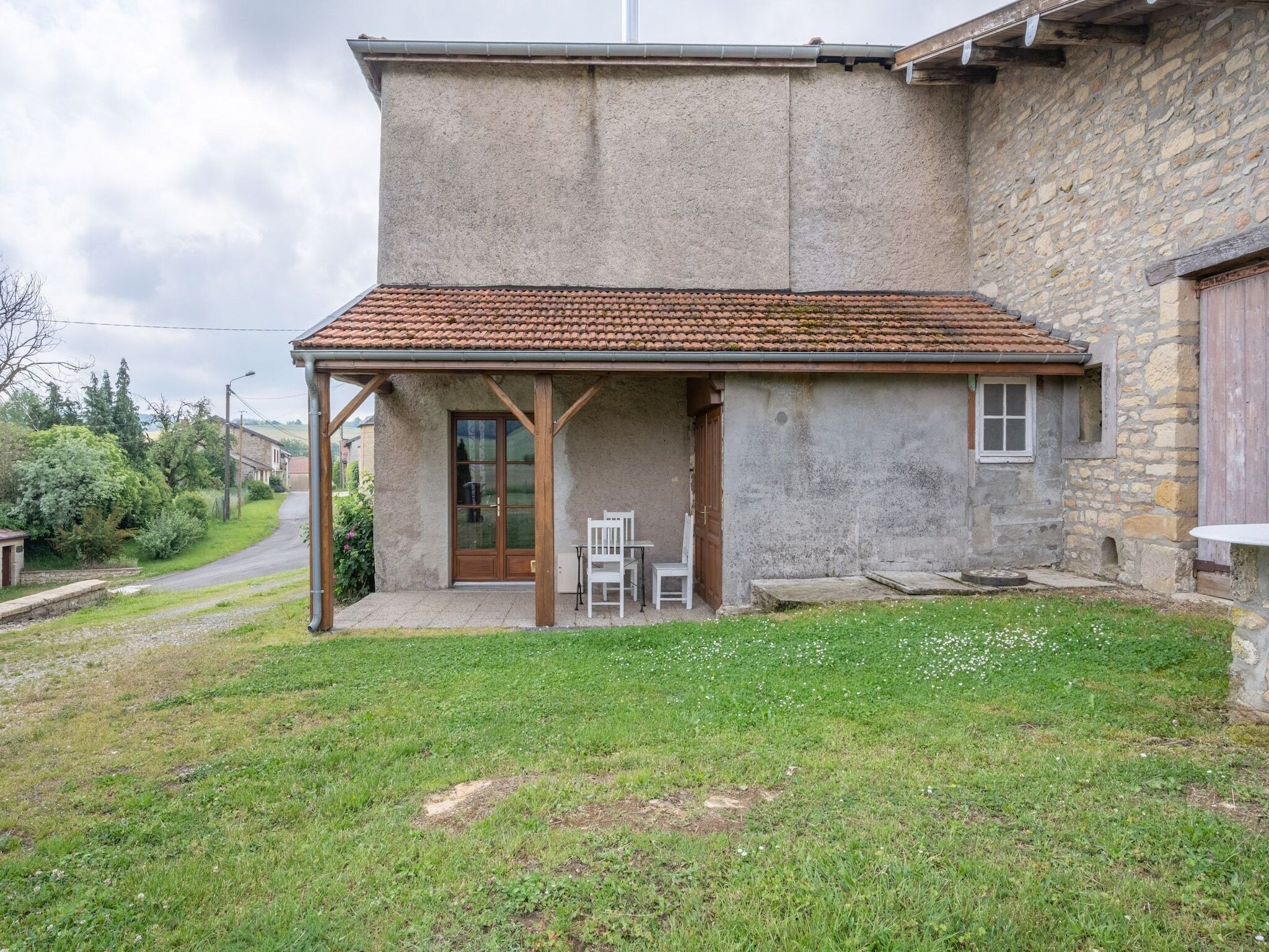 A small, single-story building with a tiled roof and a covered patio area.