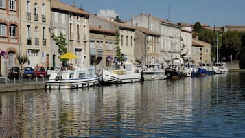 Un canal bordé de bateaux à quai, entouré d’immeubles dotés de balcons et de fenêtres.