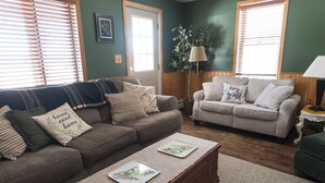 A living room with two couches, a coffee table, and a lamp.