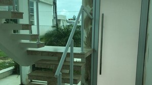 Una escalera con barandillas de metal que conduce a una puerta.