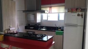 Una cocina con estufa a gas, refrigerador y microondas.