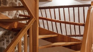 Una escalera de madera con barandilla y un rellano alfombrado.