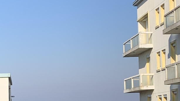 Ein Gebäude mit Balkonen mit Blick auf einen Strand.