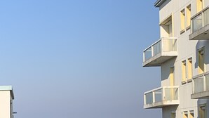 Een gebouw met balkons met uitzicht op een strand.
