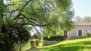 A rustic stone building with a tiled roof, surrounded by lush greenery and a well-maintained lawn. - Hilltop Mansion with Pool (Sigoulès)