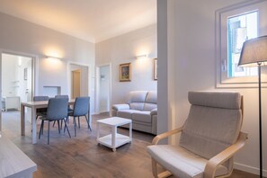 Un salon moderne comprenant un coin repas, un canapé, un fauteuil et une lampe.