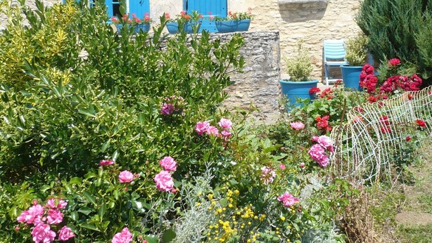 A stone building with blue shutters and a garden with pink flowers. - Holiday Home in Besse by Lake & Forest (Besse)