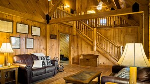 Un intérieur en bois avec un canapé en cuir, une table en bois et un escalier.