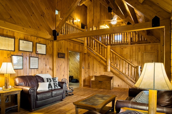 Un interior de madera con un sofá de cuero, una mesa de madera y una escalera.