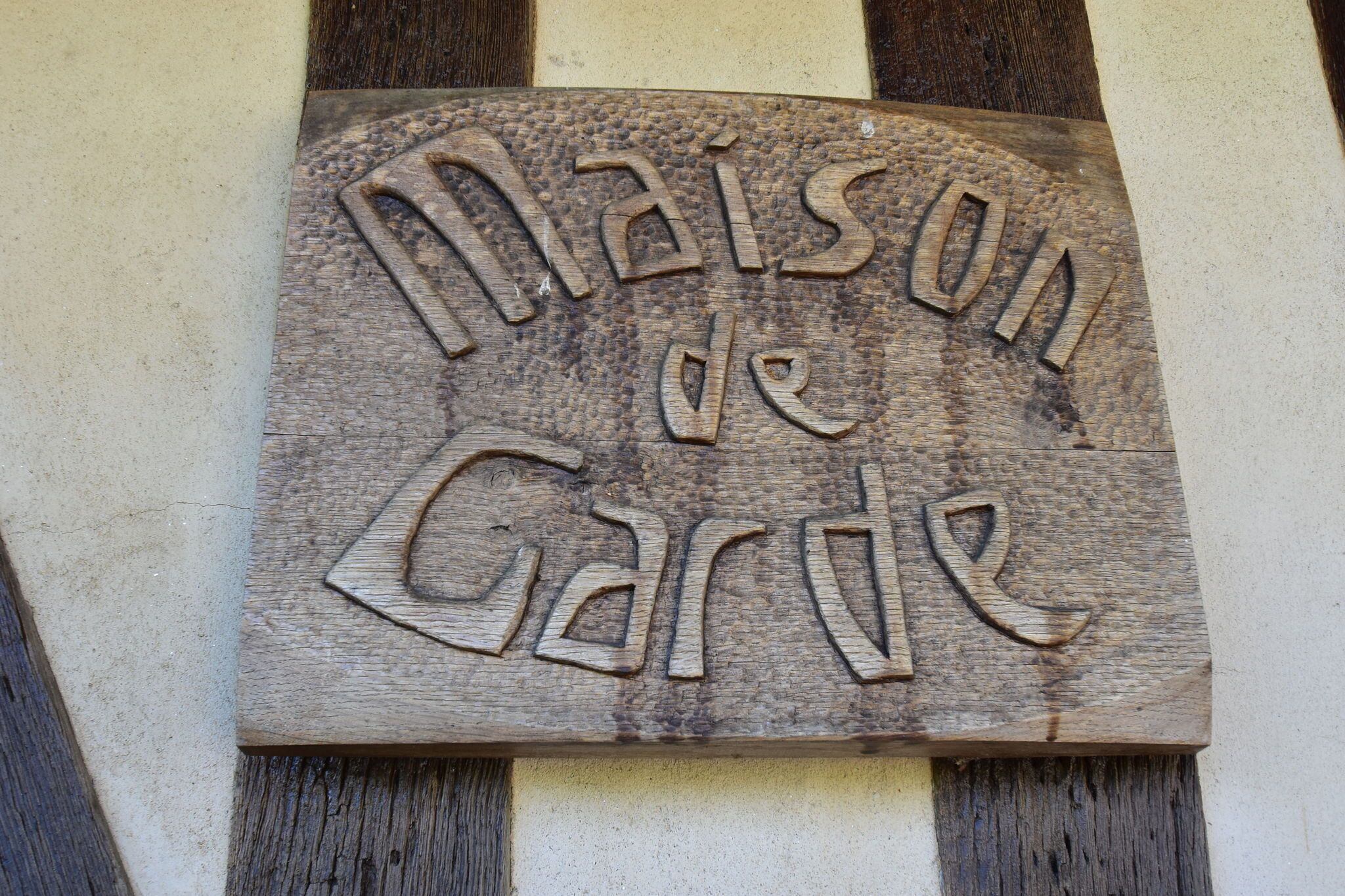 Ein hölzernes Schild mit der Aufschrift 'Maison de Gare'.