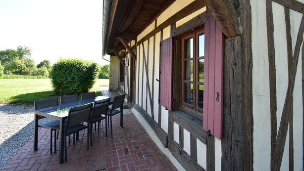 A traditional half-timbered building with a brick patio and outdoor seating area.