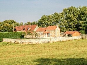 A stone house with a red-tiled roof, surrounded by a stone wall and a grassy field. - Slate-Roofed Hideaway (Cressensac)