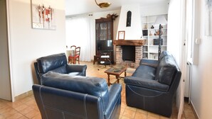 A living room with two leather sofas, a TV, a fireplace, and a bookshelf. - Saint-Germain Beach Bliss (St. Germain-Sur-Ay)