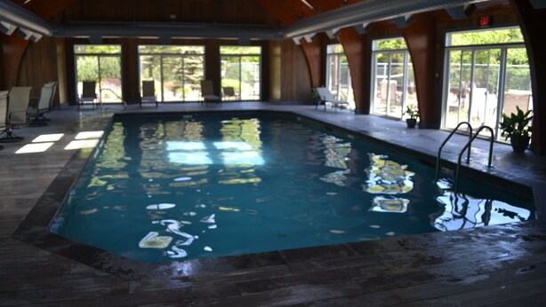 An indoor swimming pool with clear water, surrounded by wooden walls and large windows. - Condo < 1mi. from Mt. Snow / Free Shuttle (West Dover)