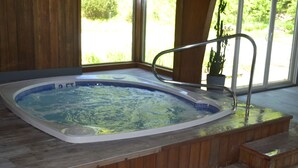 A hot tub with a wooden deck and a view of greenery outside. - Condo < 1mi. from Mt. Snow / Free Shuttle (West Dover)