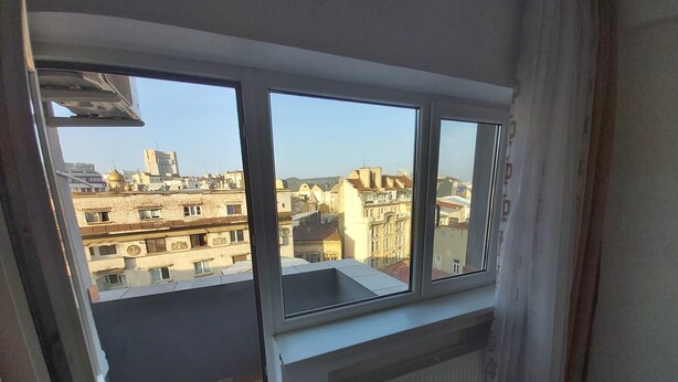 A room with a large window overlooking a cityscape.