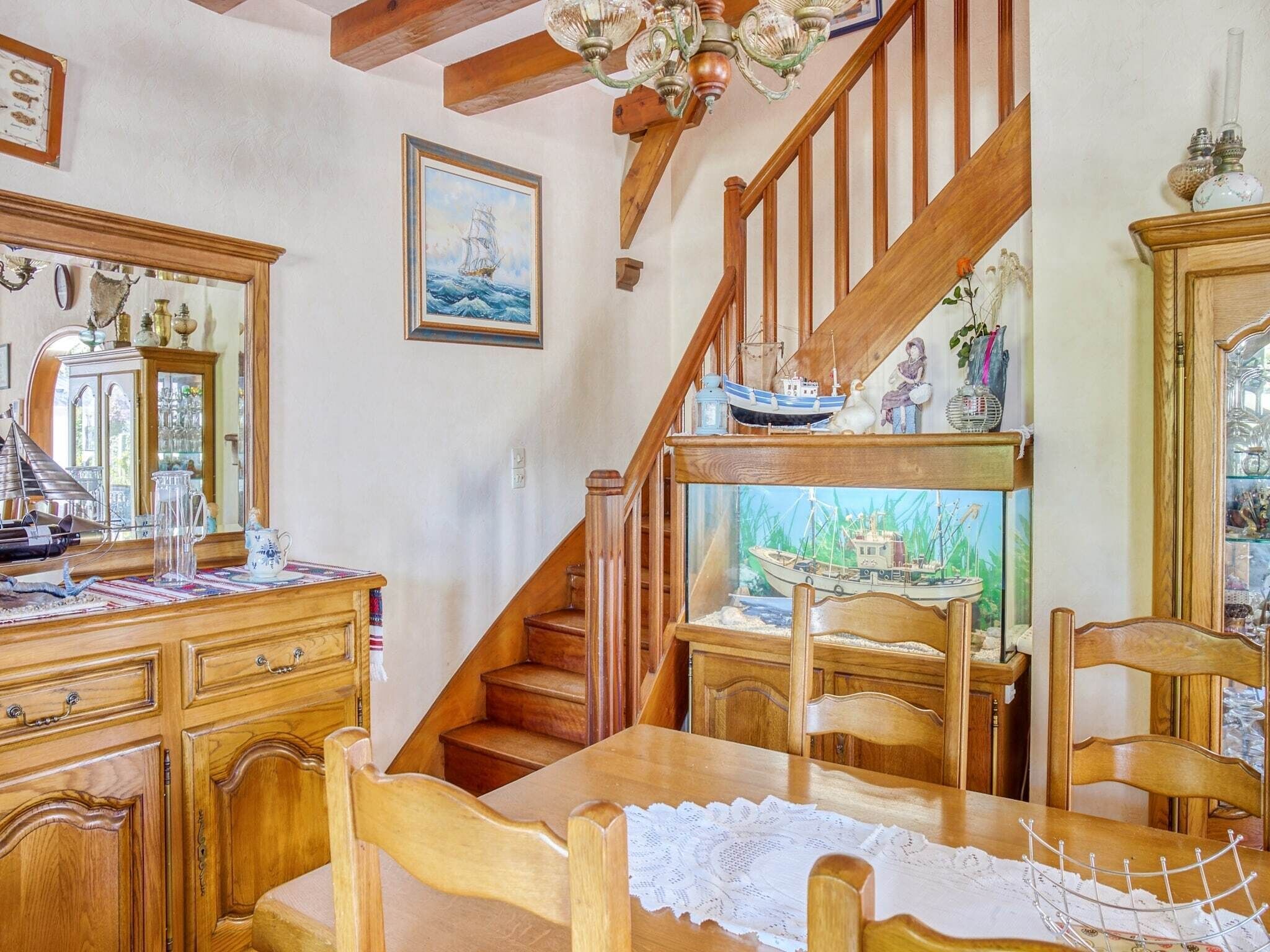 A wooden staircase with a ship model on the landing.