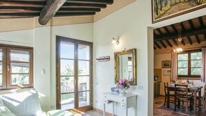 Una camera spaziosa con un'ampia finestra, un'area pranzo e un bagno con doccia.