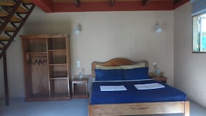 Ein Schlafzimmer mit einem Holzbett, einem Schrank aus Holz und einer Treppe.