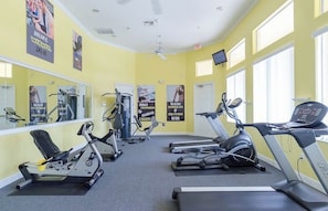A gym with exercise equipment, mirrors, motivational posters, and a ceiling fan. - Mickey’s Magic Retreat at Terra Verde Resort (Kissimmee)