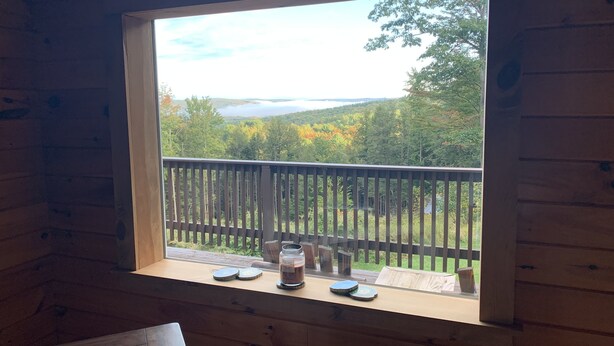 A wooden cabin with a window overlooking a forest and a lake. - Private House with Great View (Afton)