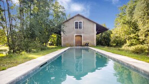 Une piscine avec une maison en arrière-plan.