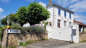 A white building with a stone wall and a sign that reads "LECOLE". - Holiday Home in Limousin near Forest (La Veytisou)