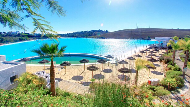 A resort with a swimming pool, sun loungers, umbrellas, and a beach area. - 2288 Luxury Penthouse with Private Rooftop Pool (Estepona)