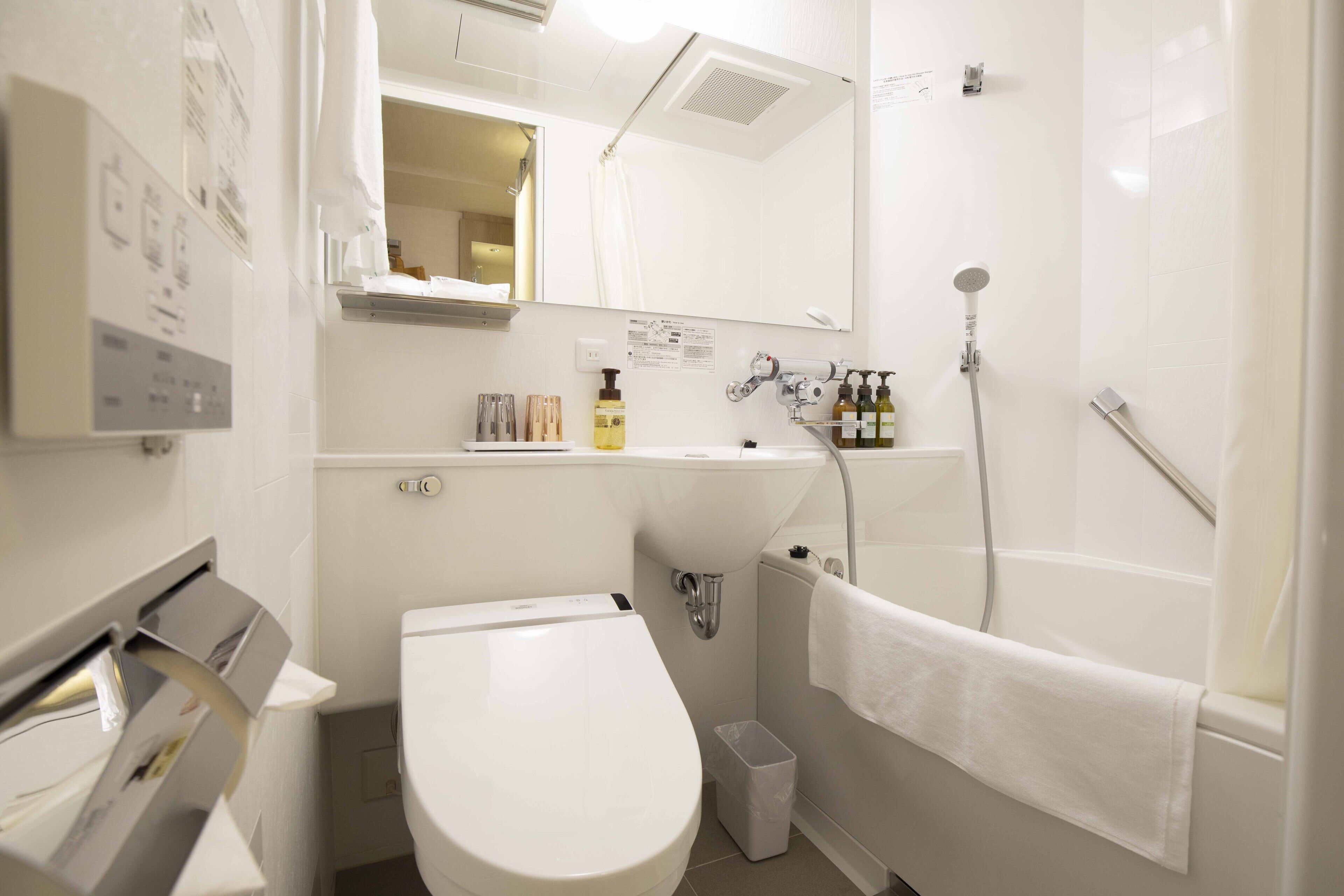 Un baño moderno con inodoro, lavamanos y ducha.