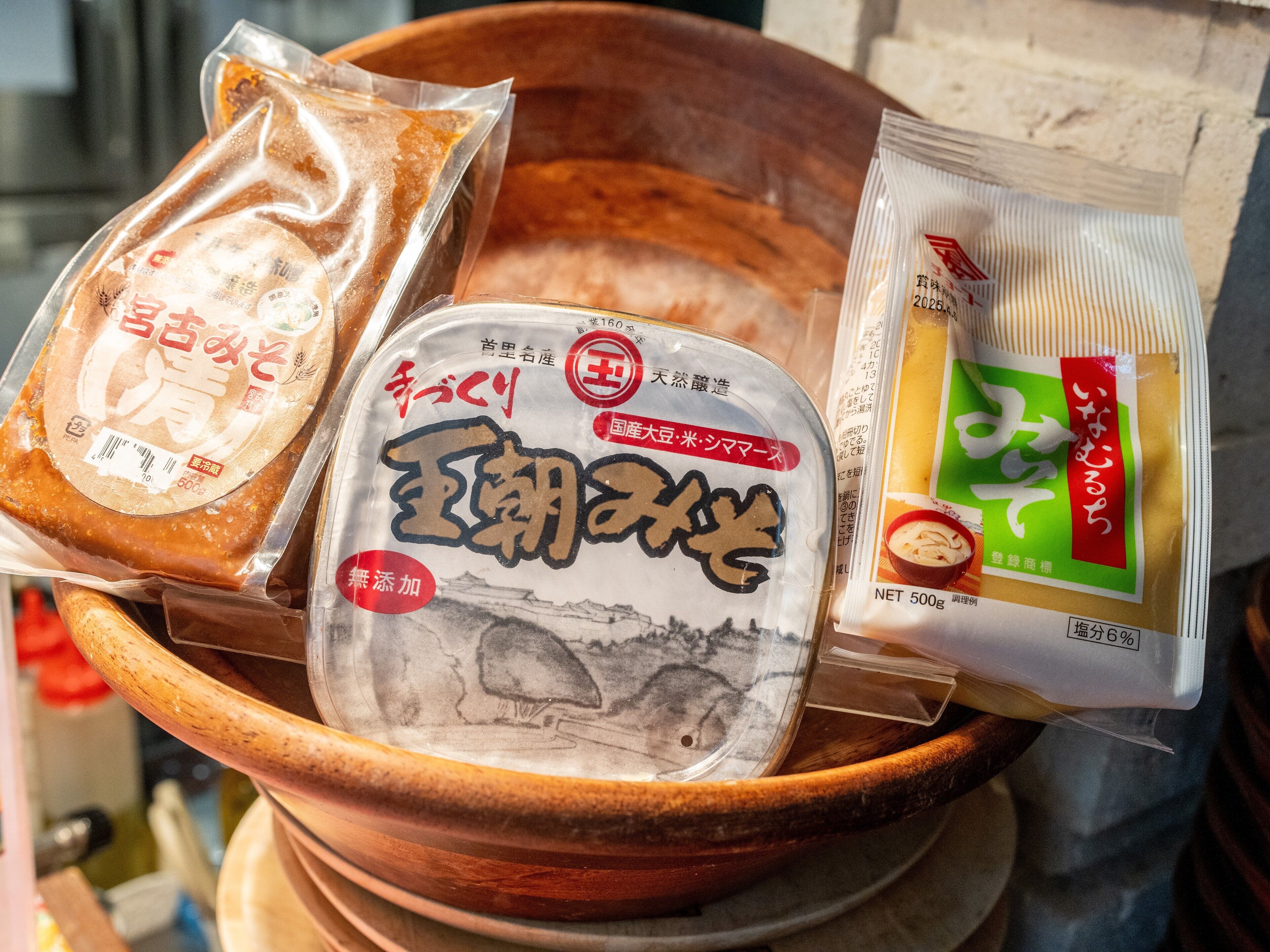 A wooden bowl containing various packaged food items.