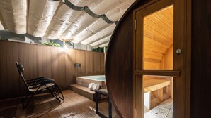 A wooden spa room with a wooden bench, a small table, and a hot tub. - Tabino Hotel lit Miyakojima (Miyakojima)