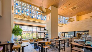 A modern cafe with wooden furniture, large windows, and ceiling fans. - Tabino Hotel lit Miyakojima (Miyakojima)