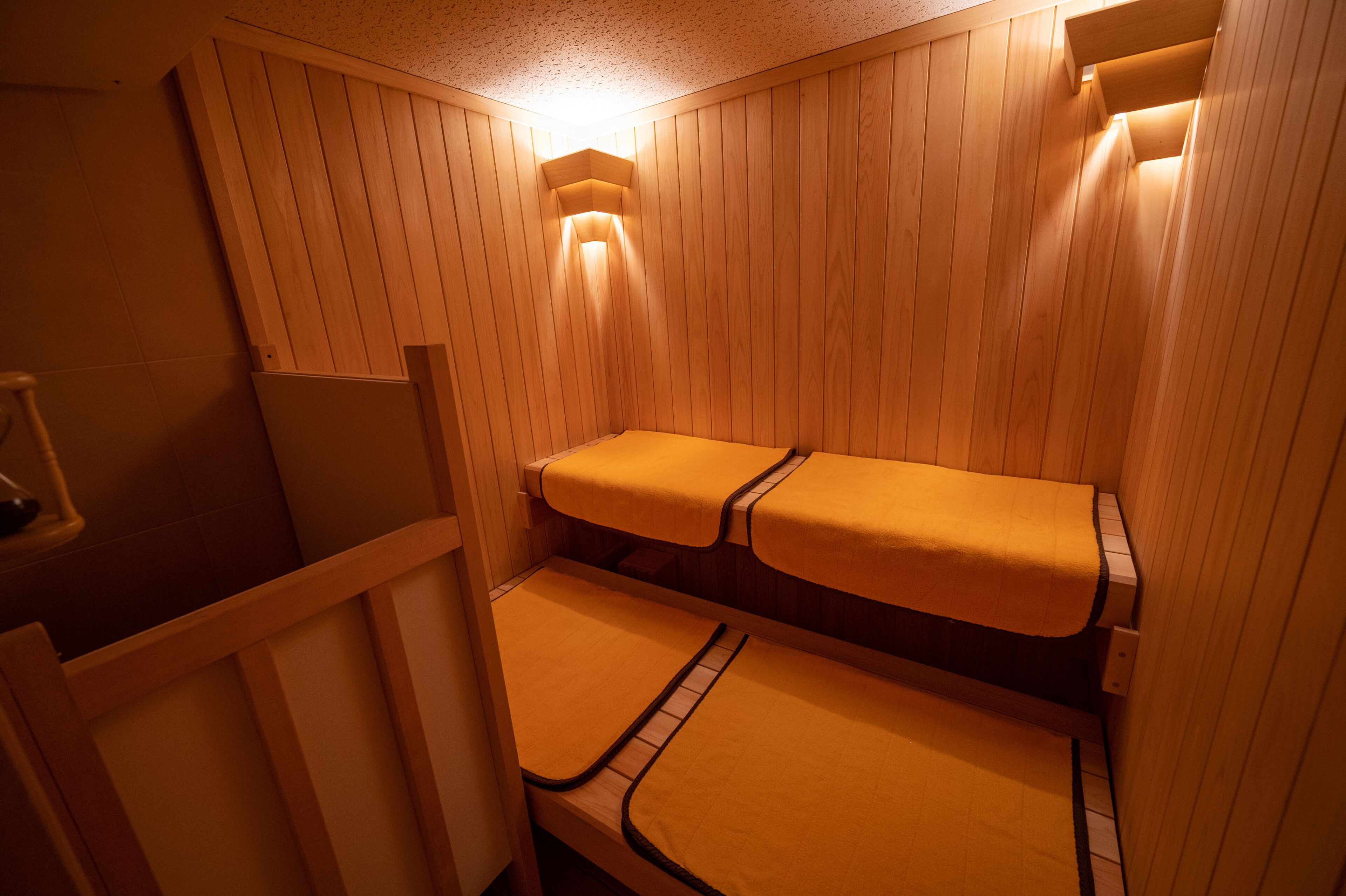 A sauna room with wooden walls and benches.