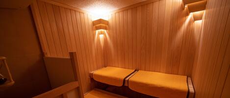 A sauna room with wooden walls and benches.